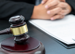A judges desk with a contract and a wooden gavel