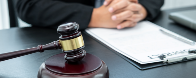 A judges desk with a contract and a wooden gavel