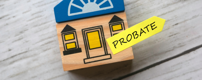 A toy wooden house with a yellow arrow sticker that says probate