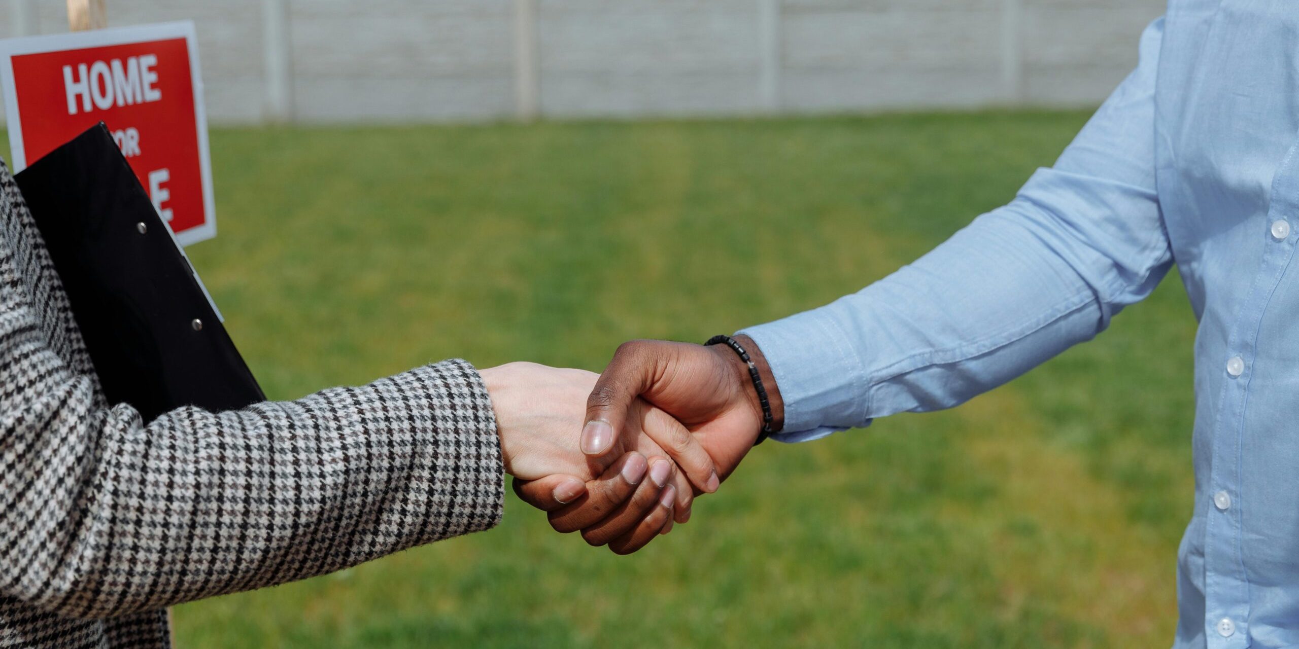 House buying Two outstretched arms shaking hands